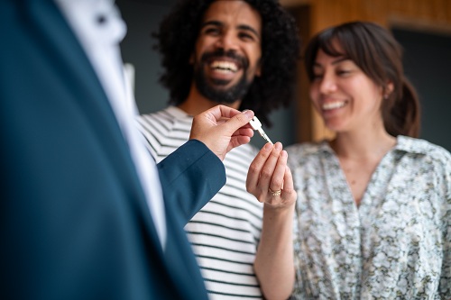 young couple receiving the keys to their future home