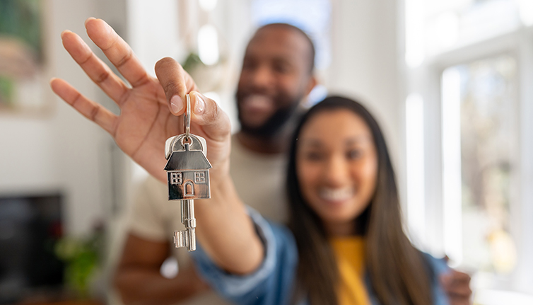 a couple showing keys to their home