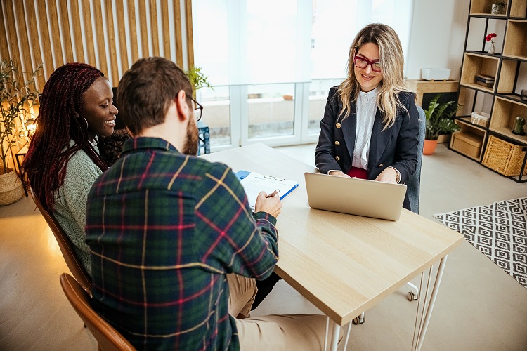 couple sitting together reviewing paperwork with an advisor
